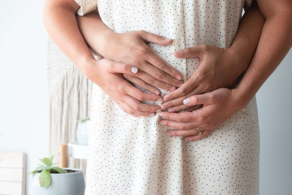 Couple holding a pregnant belly