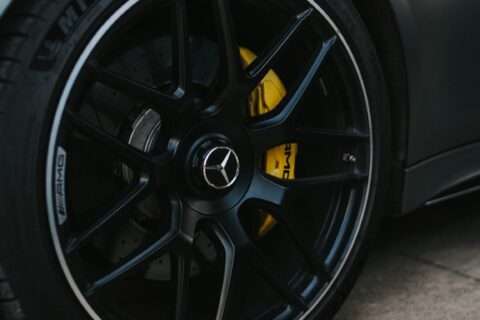 Close-up of a Mercedes-AMG wheel with yellow brake calipers and drilled brake discs.