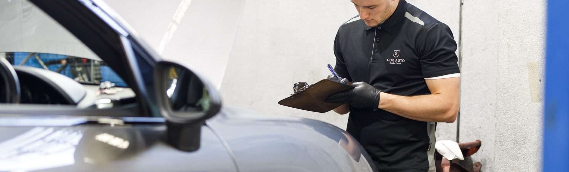 Cox Auto employee inspecting a car