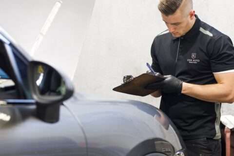 Cox Auto employee inspecting a car