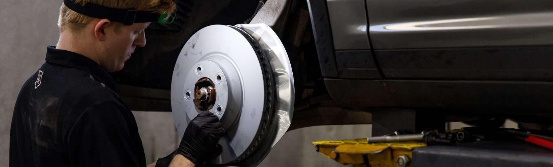 Mechanic installing a new brake disc on a vehicle.