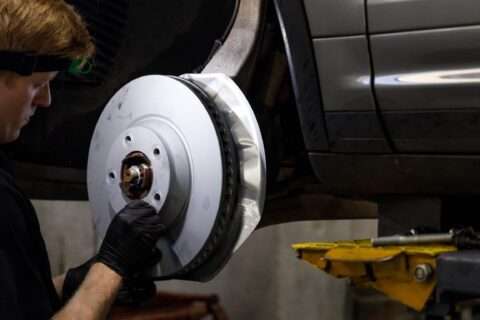 Mechanic installing a new brake disc on a vehicle.