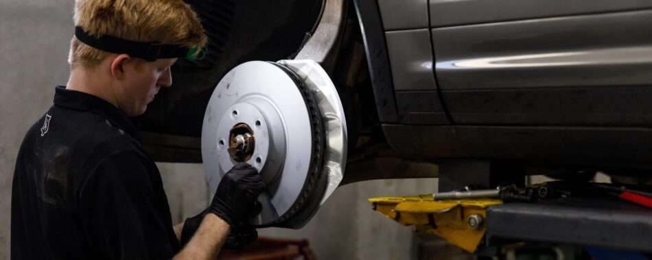 Mechanic installing a new brake disc on a vehicle.