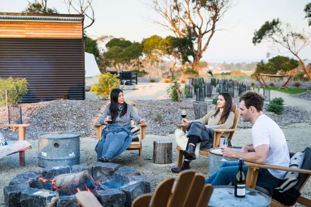 Friends drinking wine around the campfire
