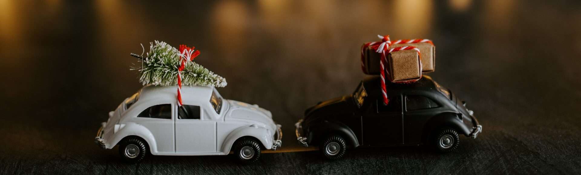 Mini toy cars with gifts and a Christmas tree on top.