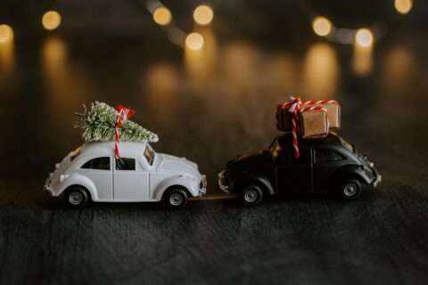 Mini toy cars with gifts and a Christmas tree on top.