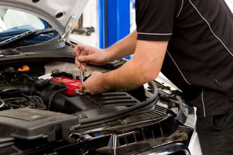 car mechanic working on a car battery