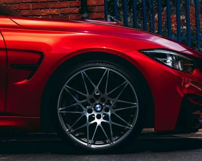 Close-up of a wheel with red brake calipers and drilled brake discs.