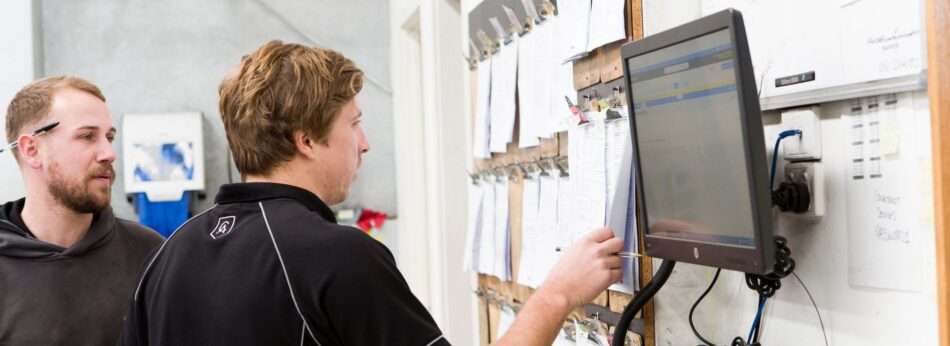 Two Cox Auto technicians review a spreadsheet of details they’ve written up as part of a pre-purchase inspection report for a client.