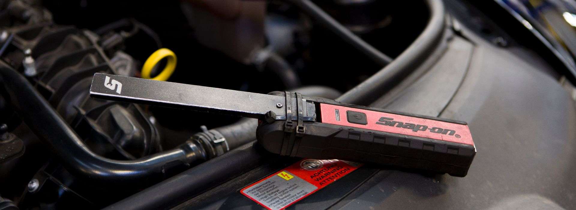 Snap-on electrical test tool resting in an engine bay