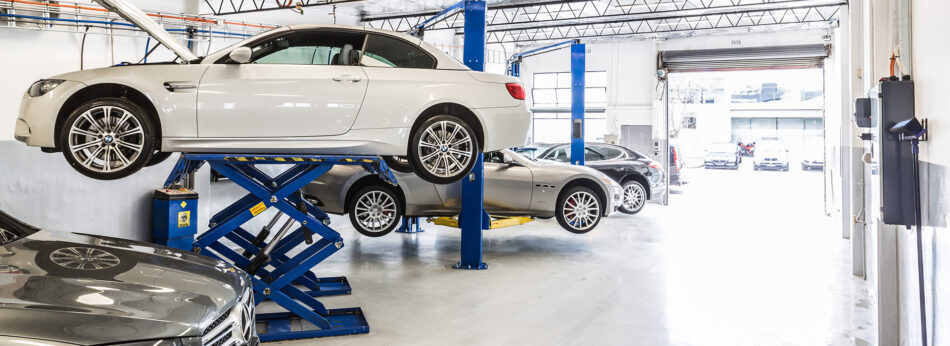 Four luxury cars up on car lifts in Cox Auto’s South Melbourne garage, waiting for our qualified mechanics to continue assessing them for roadworthiness.