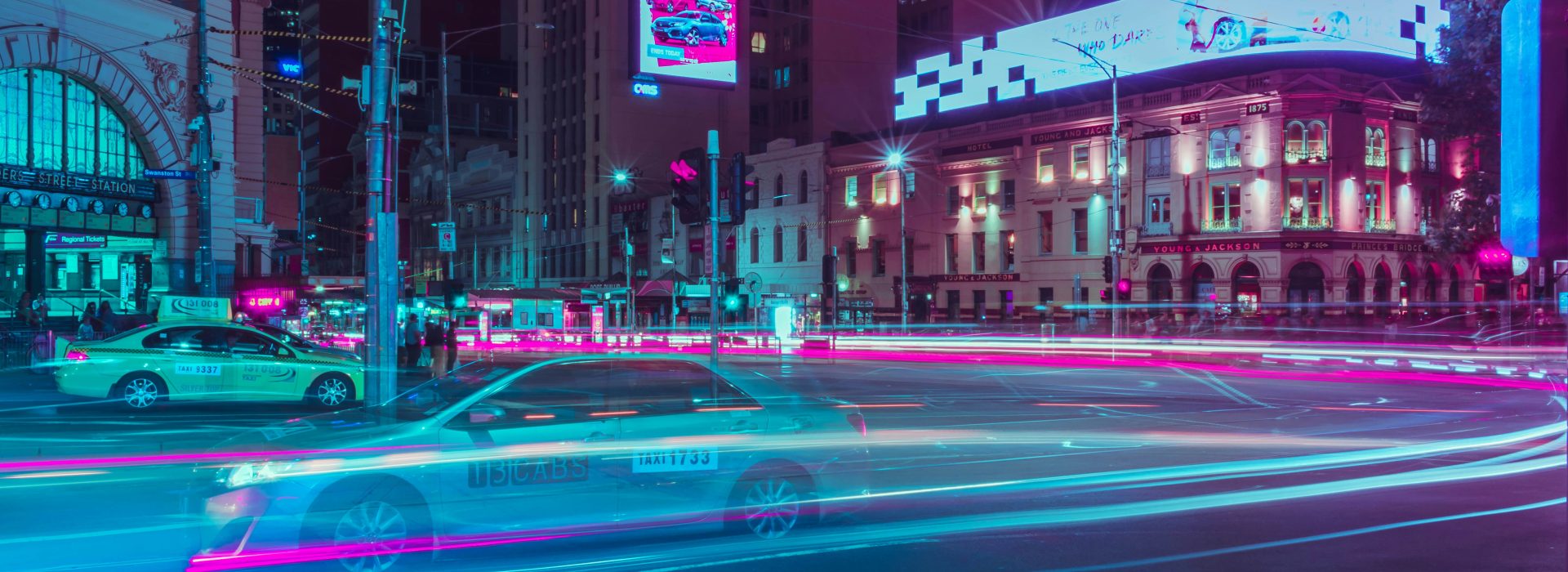 Long exposure image of cars at night near Flinders Street station. Implies futuristic scene.