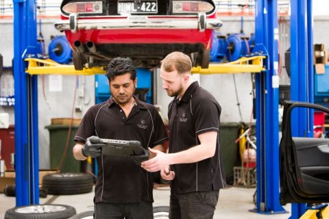 Two mechanics look at an OSB scanner