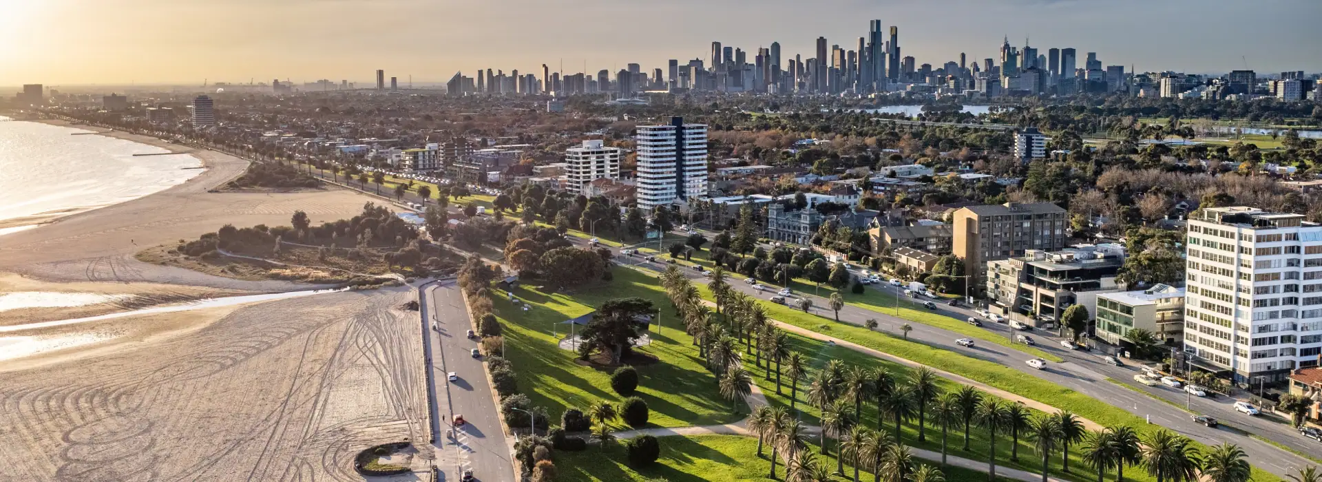 Vibrant aerial view of Melbourne's skyline with city skyscrapers, lush parks, and coastal beaches, showcasing Melbourne's urban lifestyle and scenic landscapes.